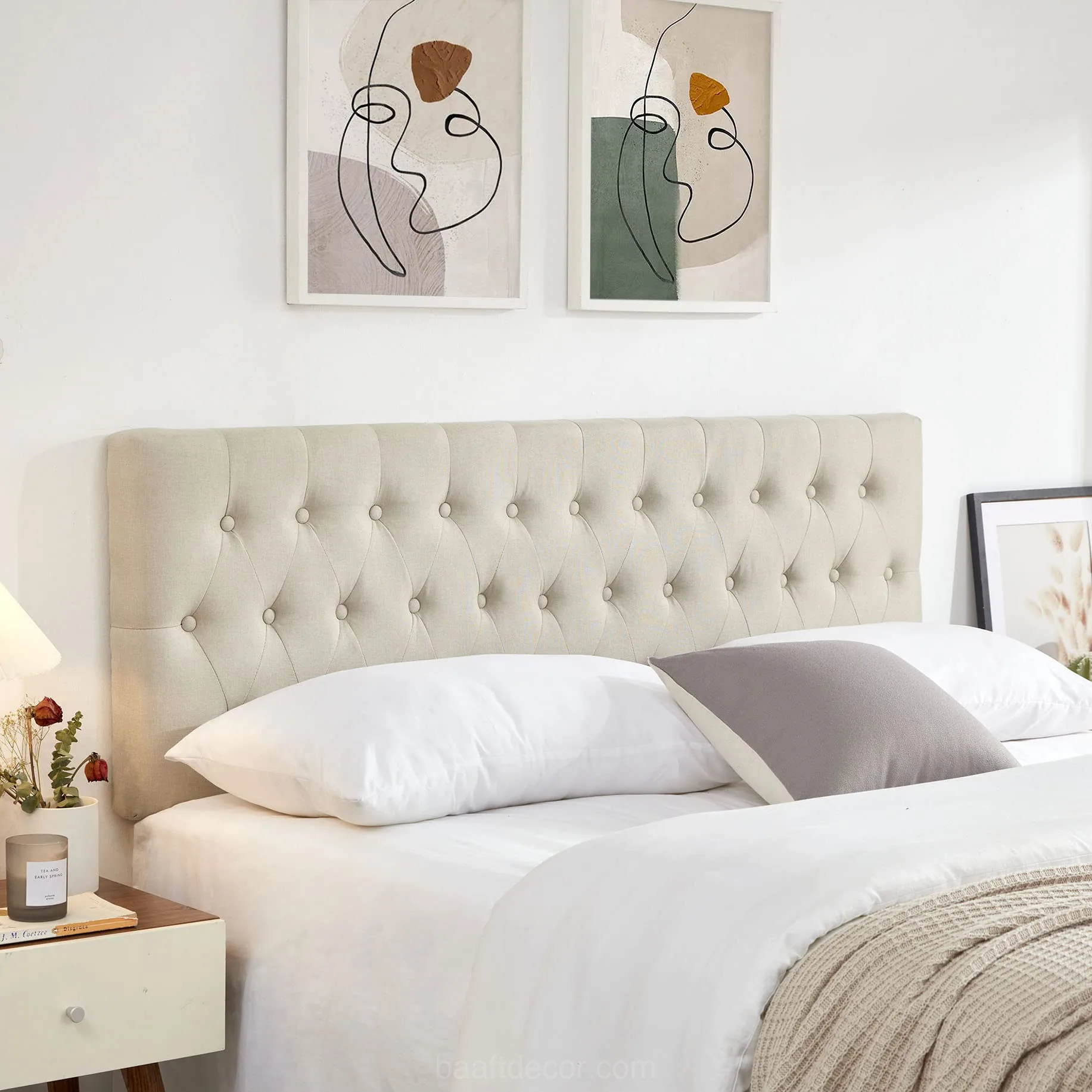a bed with a white headboard and pillows