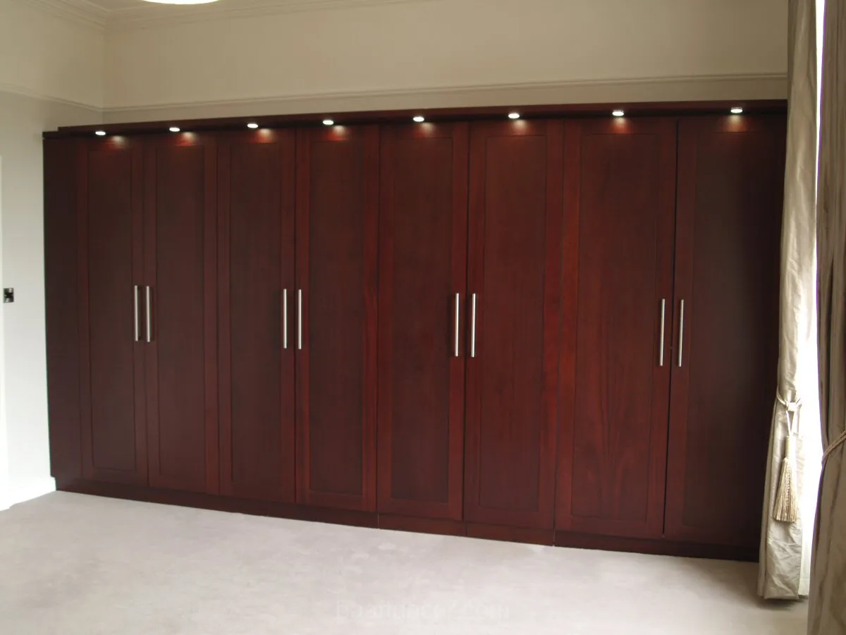 a bedroom with a large wardrobe and a large window