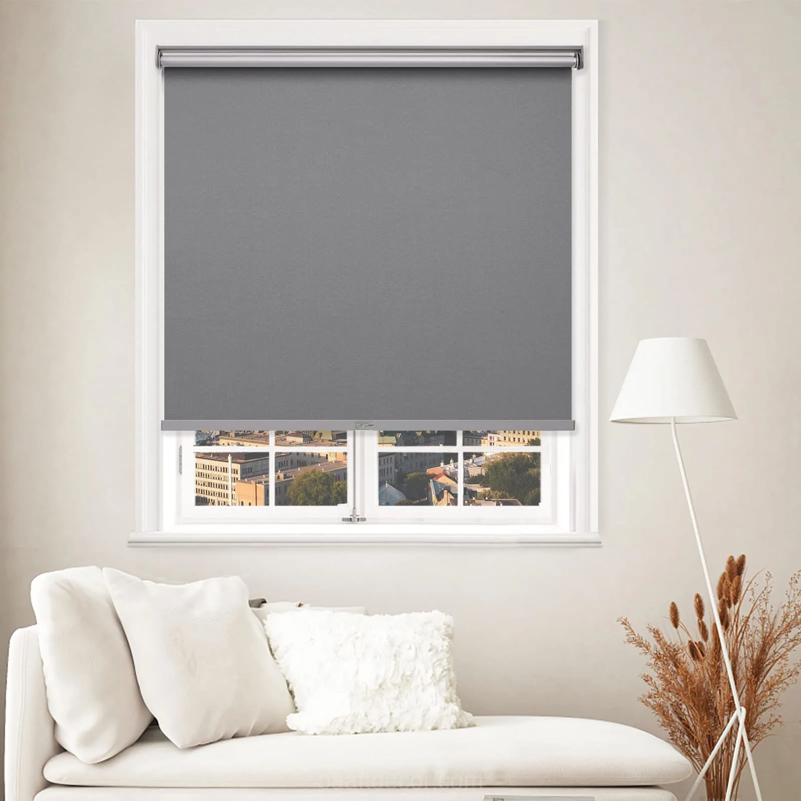 a living room with a couch and a window with a roller shade