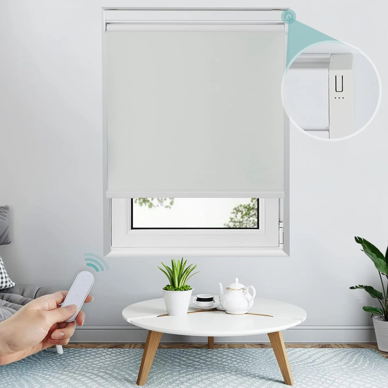 Hand holding a remote control to lower a grey motorized roller blind over a window