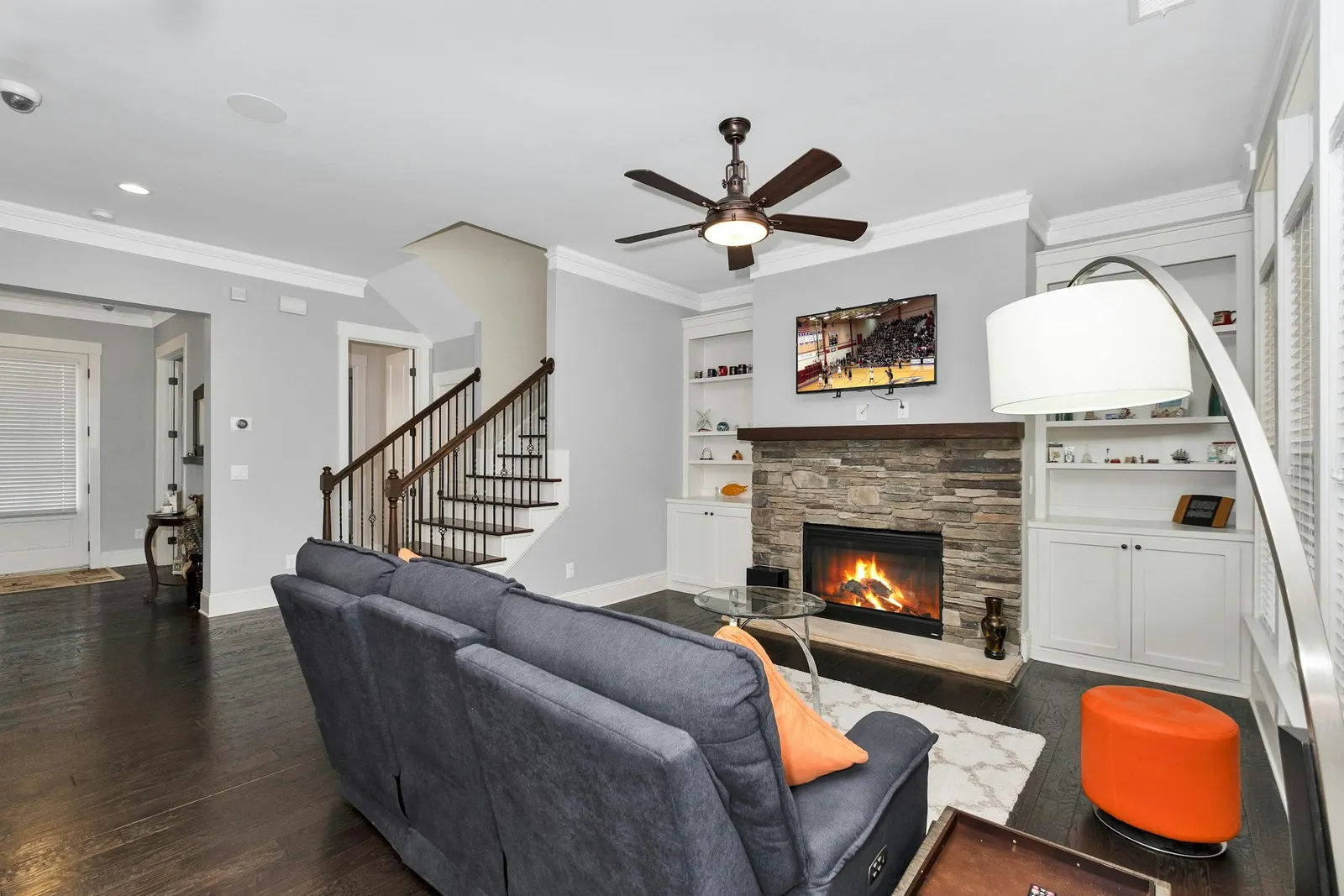 Grey fabric reclining sofa facing a wall-mounted TV in a living room