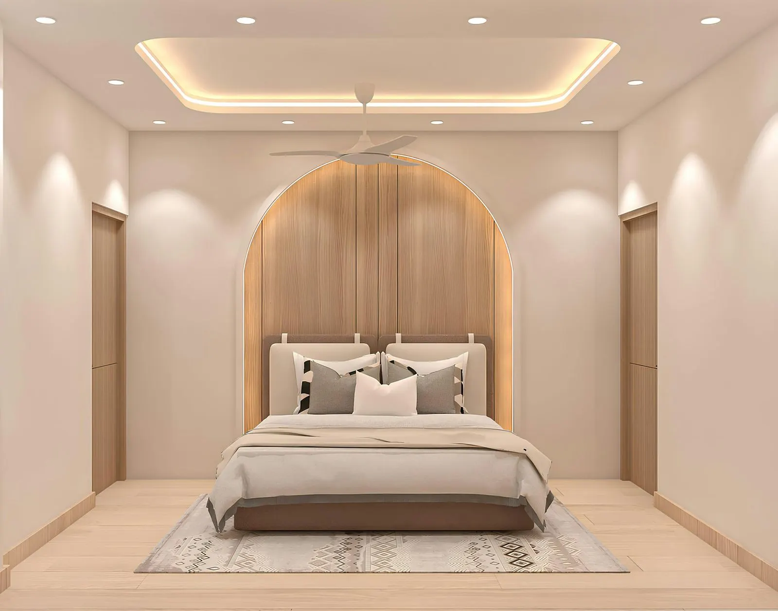 Bedroom with a recessed tray ceiling ringed by warm cove light, a ceiling fan hanging from its centre, downlights near the walls and an arched wood panel behind the bed