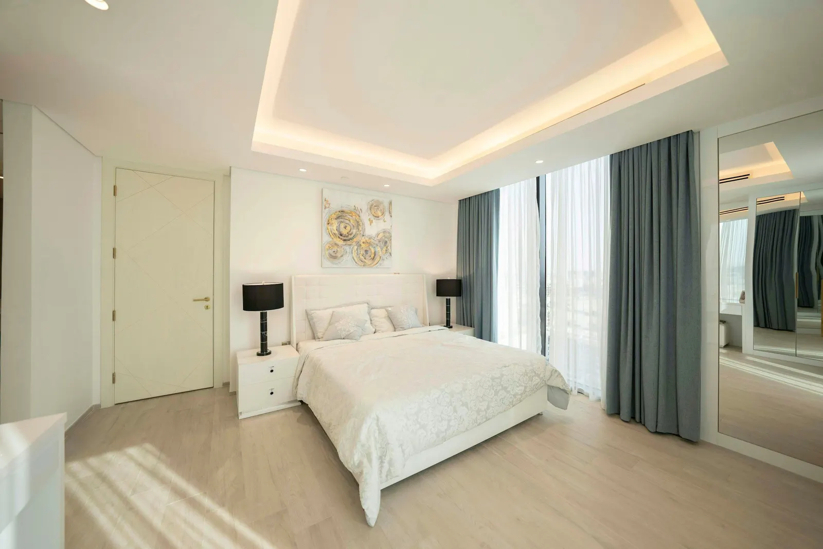 Bright bedroom with a single-step peripheral false ceiling and warm cove lighting around the centre