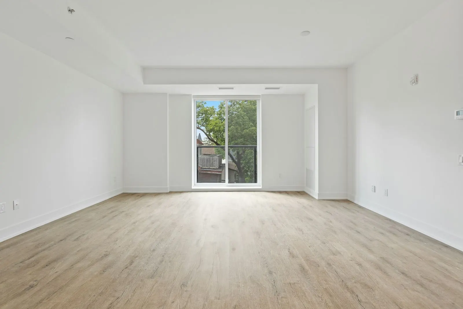 Empty living room in a new apartment with a sliding glass door to the balcony
