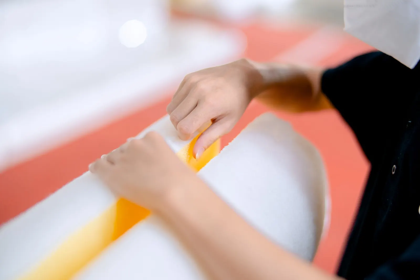 Close-up of hands working a block of white polyurethane foam