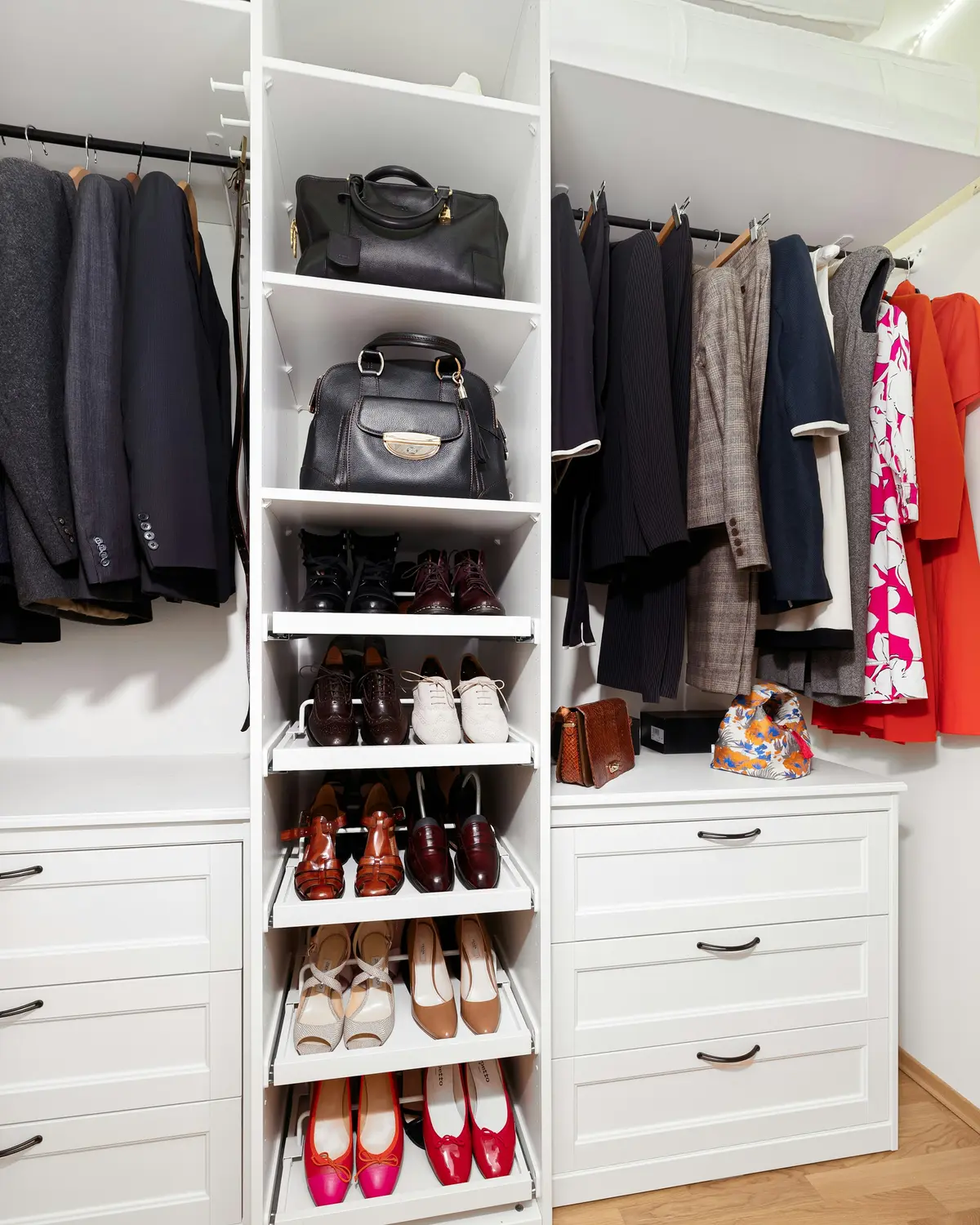 White wardrobe with short hanging for jackets, longer hanging for dresses, a centre tower of bag shelves and pull-out shoe shelves, and drawers below
